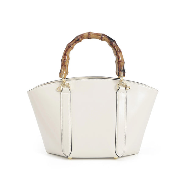 Structured trapezoid handbag with segmented bamboo top handle, smooth leather-look finish, gold-tone hardware, and vertical