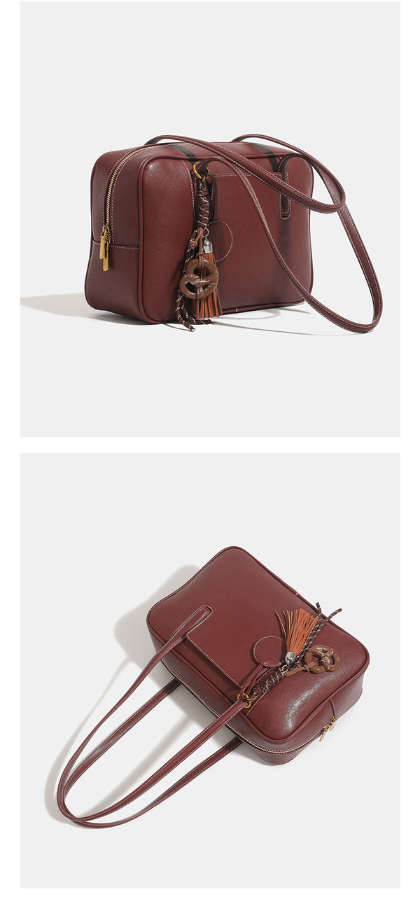 Structured rectangular leather-look shoulder bag with top zip, tassel and resin ring charm, and contrast topstitching, detail