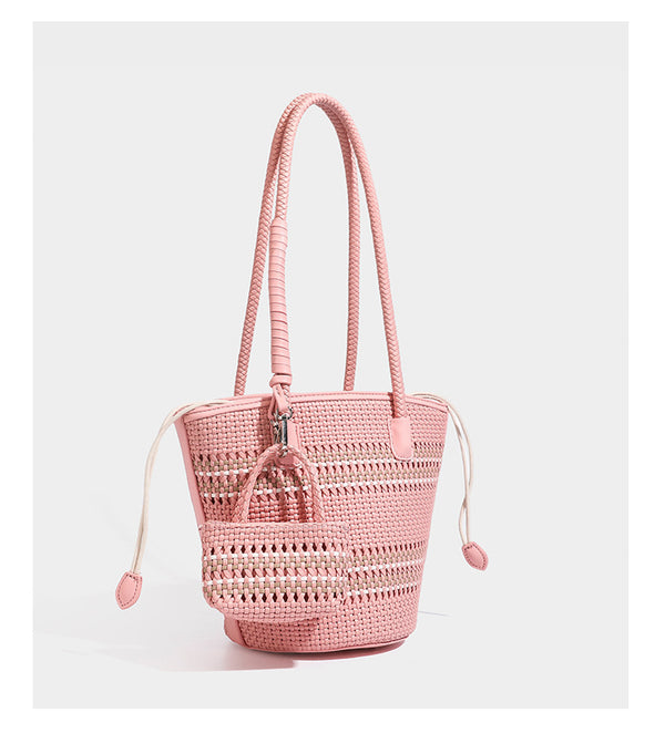 Light blue open-weave woven bucket tote bag with long braided shoulder straps, drawstring side ties, and attached mini pouch