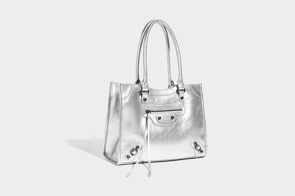 Large structured leather-look tote bag with front zip pocket, moto hardware accents, and long double shoulder straps, detail