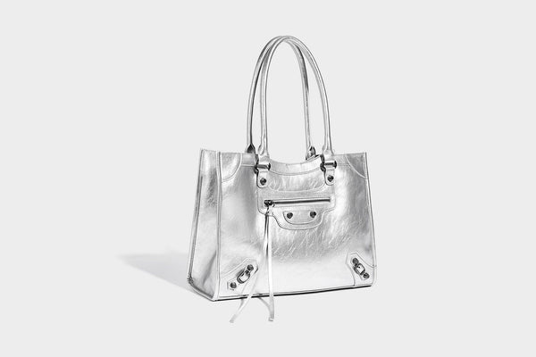 Large structured leather-look tote bag with front zip pocket, moto hardware accents, and long double shoulder straps, detail