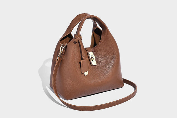 Structured pebbled-texture bucket bag with arched top handles, gold-tone turn-lock closure, and detachable shoulder strap