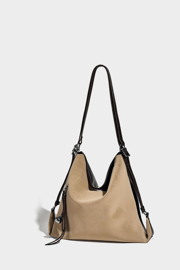 Slouchy hobo tote bag with matte leather-look finish, triangular silhouette, front zip pocket, and adjustable shoulder strap