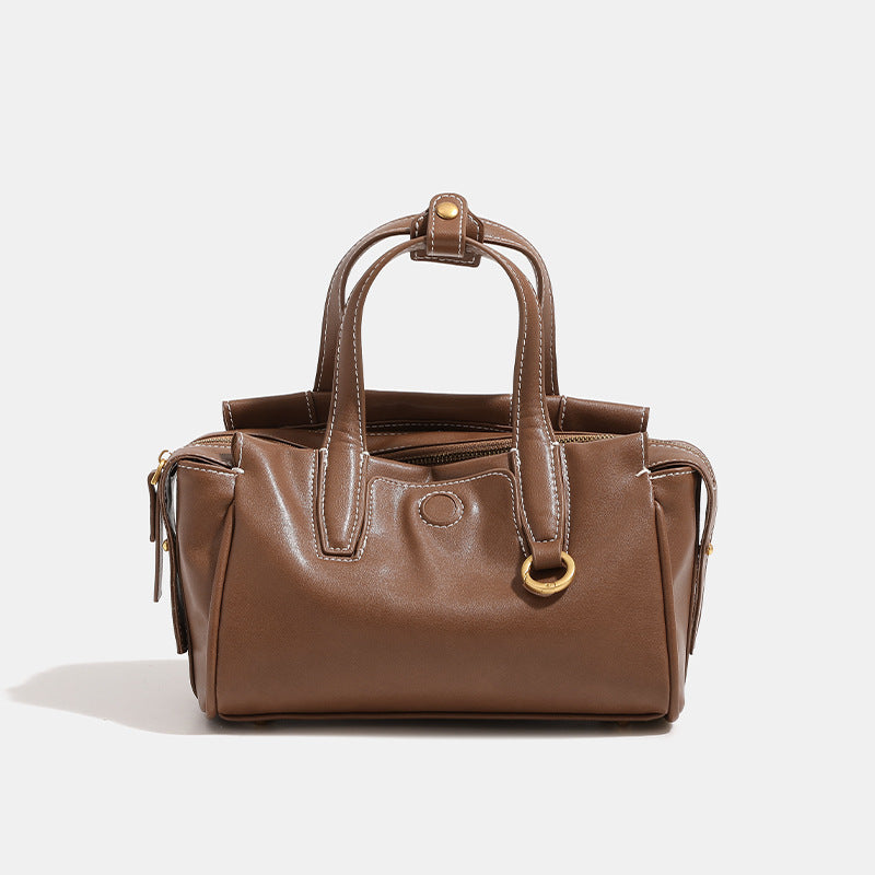 Compact structured satchel bag with dual top handles, gold-tone O-ring hardware, contrast topstitching, and detachable