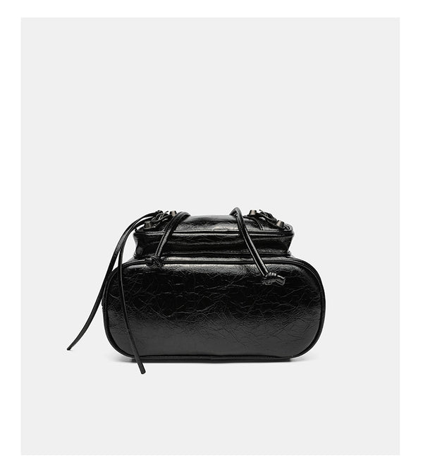 Small structured glossy leather-look convertible backpack handbag in black with flap closure, front zip pockets, metal stud