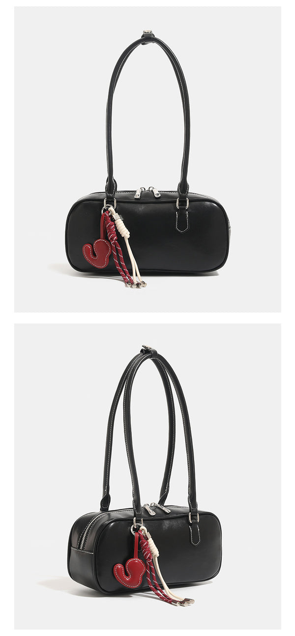 Compact rounded baguette shoulder bag with smooth leather-look finish, slim double straps, silver-tone zipper hardware, and