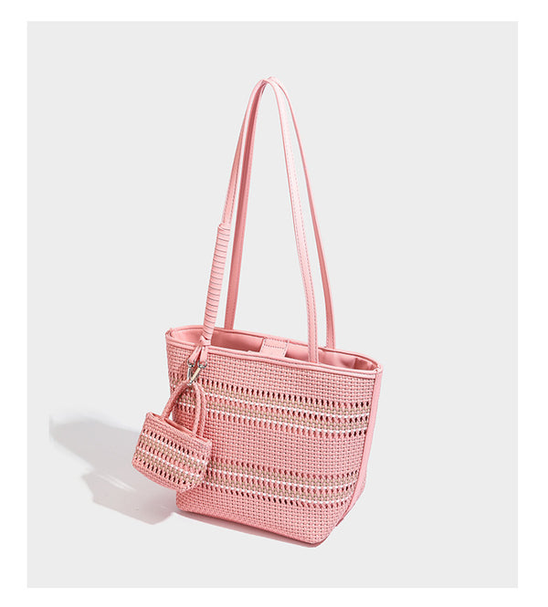 Large structured woven tote bag with striped basket-weave finish, long shoulder straps, and detachable mini pouch charm