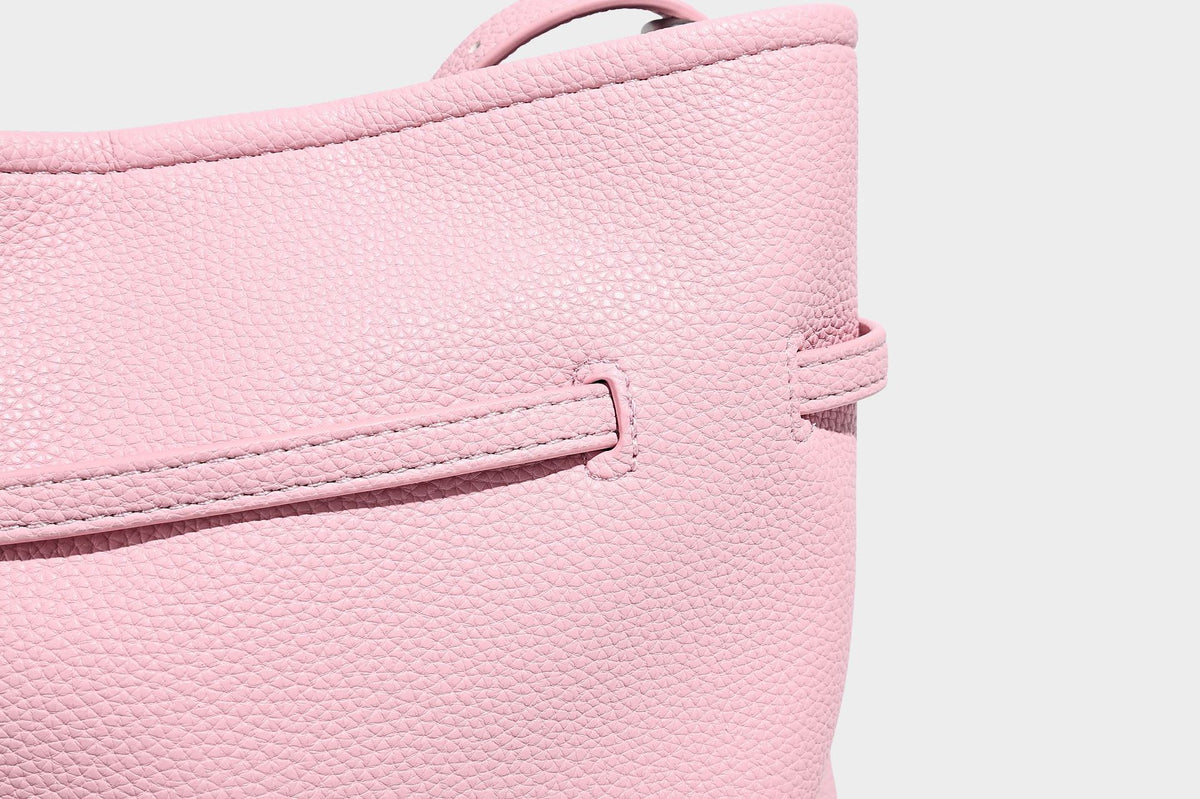 Small pebbled leather-look bucket bag with front drawstring toggle hardware and long adjustable shoulder strap, detail view