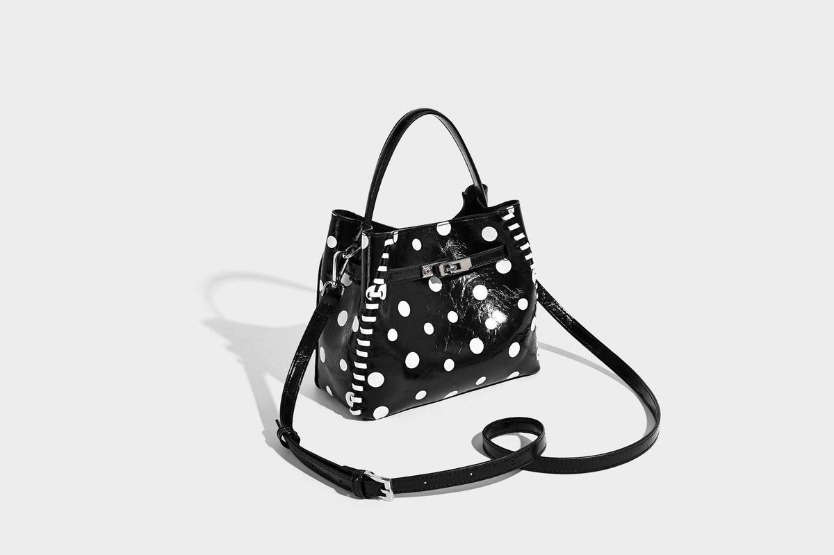 Glänzende, geknautschte Beuteltasche mit Polka-Dots, silberfarbenen Schnallenbeschlägen, kontrastierendem seitlichem Schnürbesatz, Tragegriff und abnehmbarem