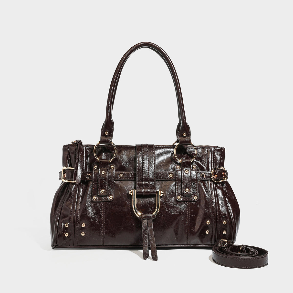 Dark brown glossy leather-look structured satchel tote with gold-tone studs, buckle straps, dual top handles, and detachable