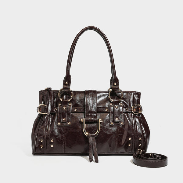 Dark brown glossy leather-look structured satchel tote with gold-tone studs, buckle straps, dual top handles, and detachable