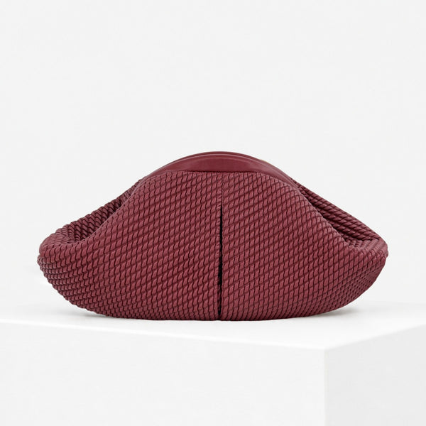 Abgerundete Clutch mit gewebter Struktur, glattem kontrastierendem Besatz und Reißverschluss in tiefem Burgunderrot, Vorderansicht