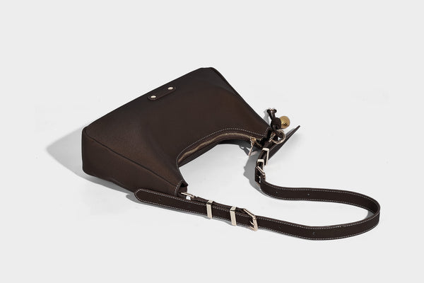 Crescent hobo shoulder bag in pebbled leather-look finish with top zipper, adjustable strap, gold-tone ring hardware, and