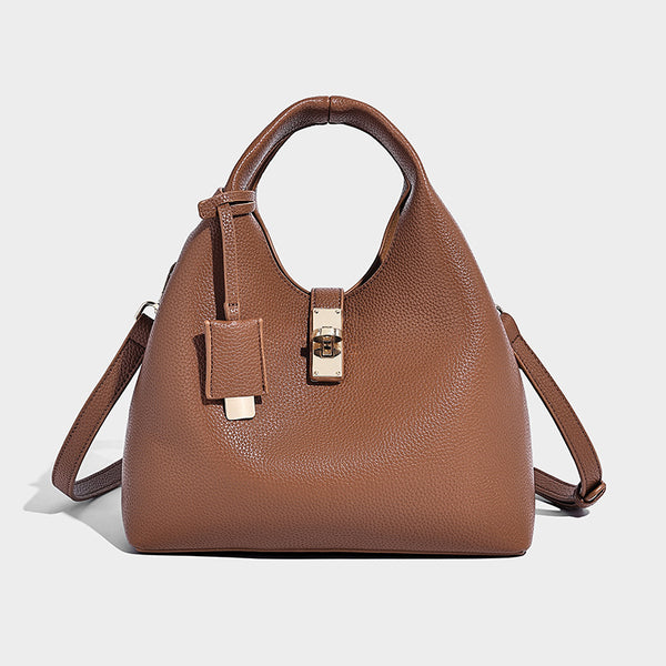 Structured pebbled-texture bucket bag with arched top handles, gold-tone turn-lock closure, and detachable shoulder strap