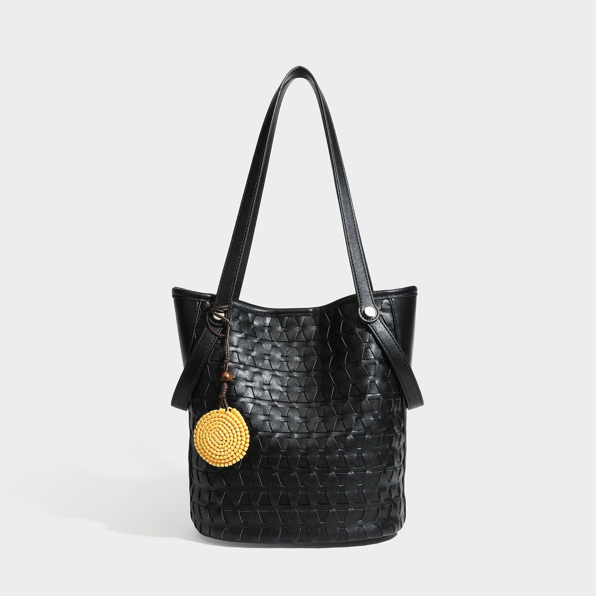Brown embossed geometric woven leather-look bucket tote bag with dual shoulder straps, side snap hardware, and a round