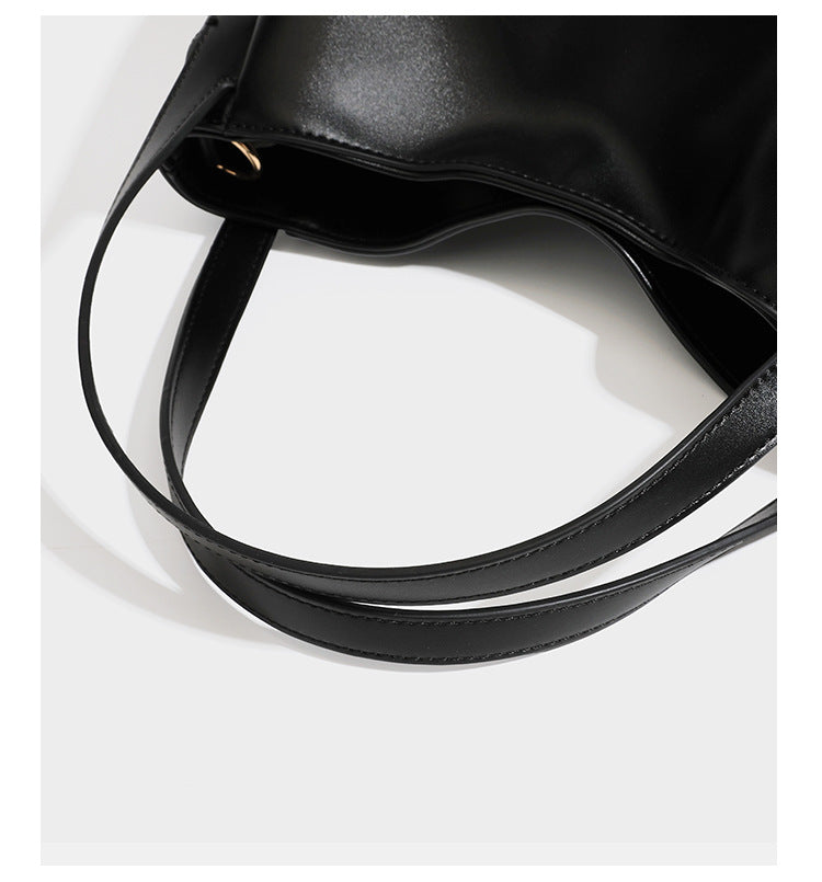 Structured glossy leather-look tote shoulder bag with dual top handles, detachable crossbody strap, side pockets, and, detail