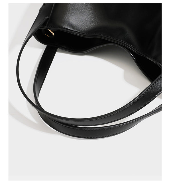 Structured glossy leather-look tote shoulder bag with dual top handles, detachable crossbody strap, side pockets, and, detail