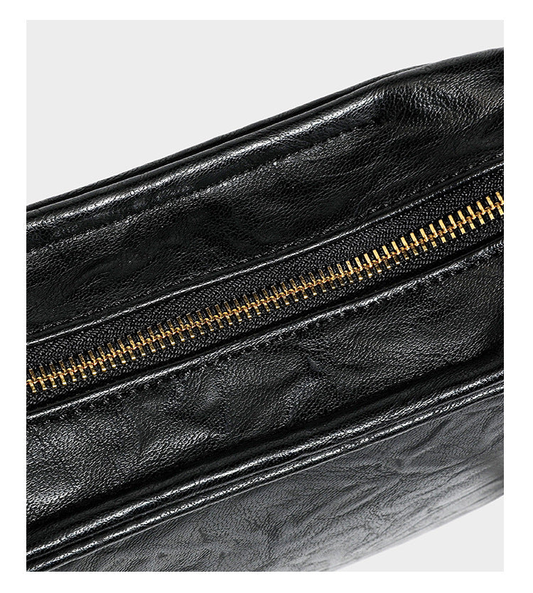 Compact black crinkled leather-look baguette shoulder bag with gold-tone arch hardware and adjustable strap, detail view 20