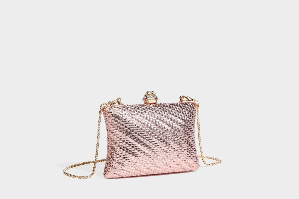 Small structured rectangular metallic woven-texture clutch bag with jeweled knob clasp and gold-tone chain strap, detail view