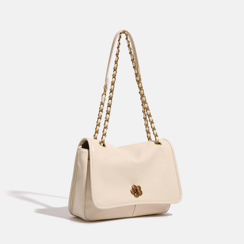 Structured flap shoulder bag with antique gold-tone chain strap and flower turn-lock clasp in crinkled leather-look finish