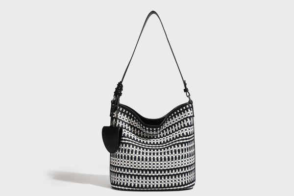 Woven stripe bucket shoulder bag in cream and dark brown with leather-look trim, knotted adjustable strap, and small shield