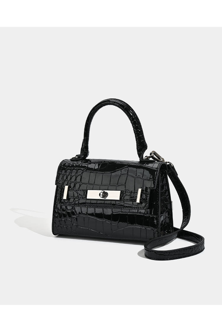 Strukturierte Mini-Henkeltasche in glänzender Lederoptik mit Krokoprägung und silberfarbenen Drehverschlussdetails sowie