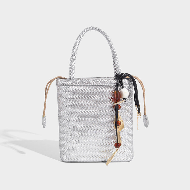 Small structured woven-texture tote bag with braided top handles and drawstring inner pouch, detail view 3