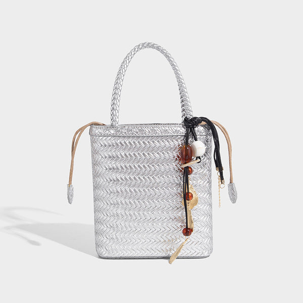Small structured woven-texture tote bag with braided top handles and drawstring inner pouch, detail view 3