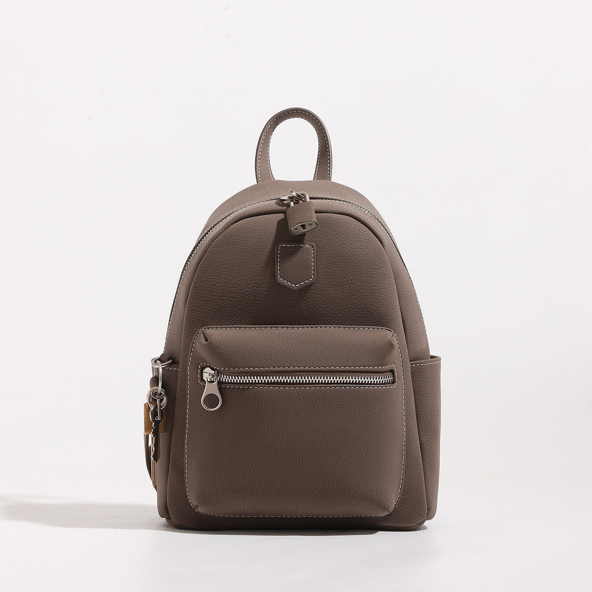 Mini rounded pebbled-finish backpack handbag with silver-tone hardware, front zip pocket, and convertible shoulder straps