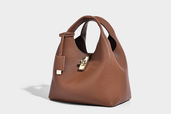 Structured pebbled-texture bucket bag with arched top handles, gold-tone turn-lock closure, and detachable shoulder strap