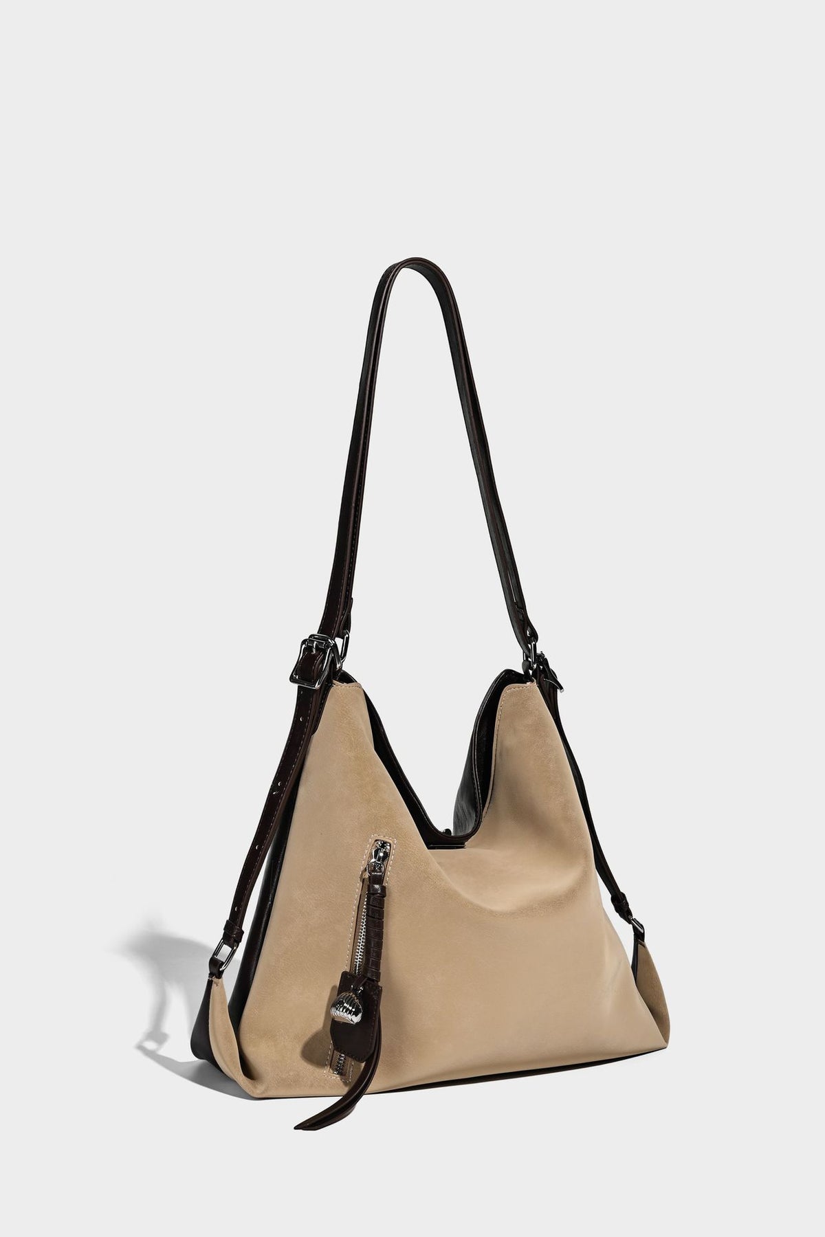 Slouchy hobo tote bag with matte leather-look finish, triangular silhouette, front zip pocket, and adjustable shoulder strap