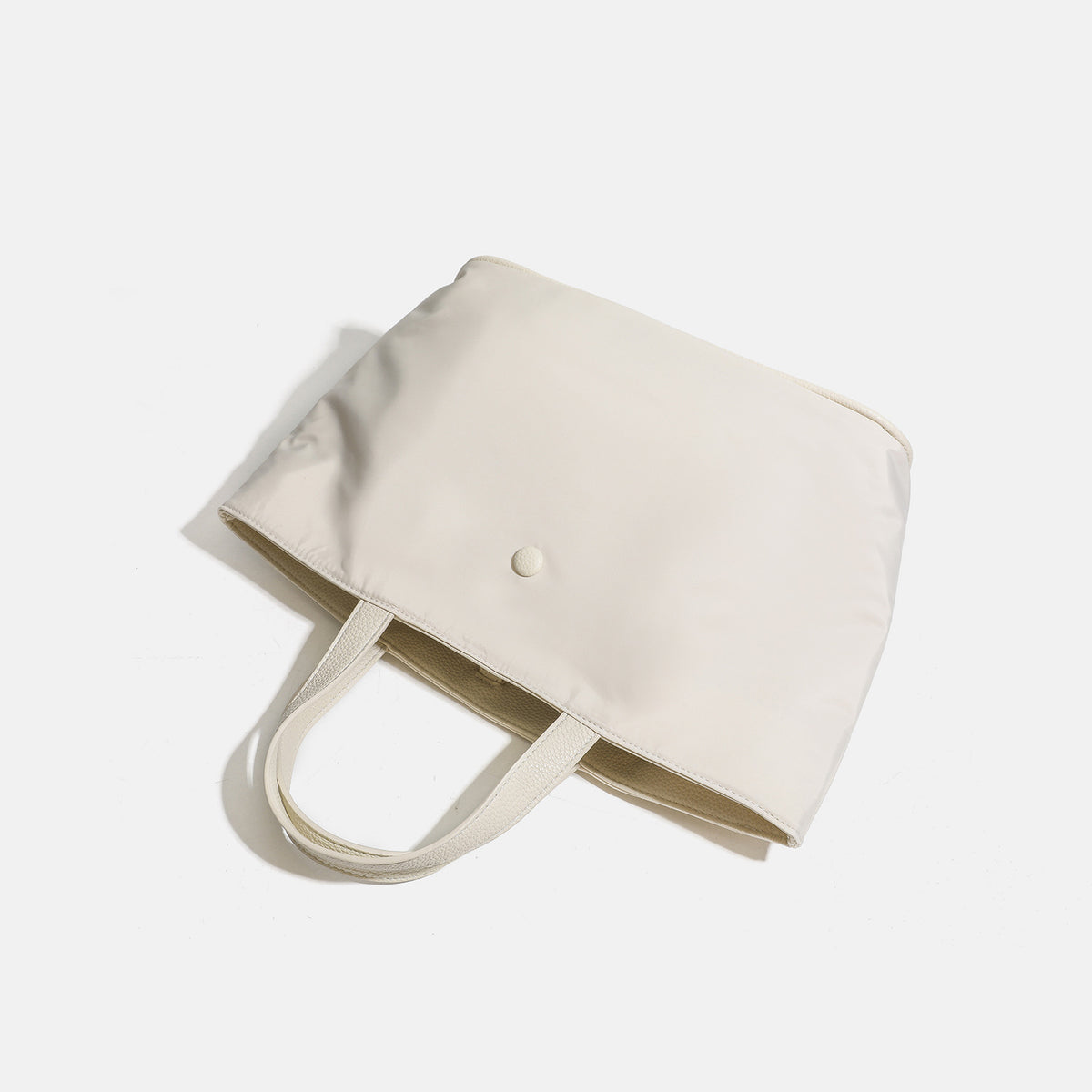 Structured lightweight nylon tote bag with textured double top handles and snap-button front detail, detail view 4