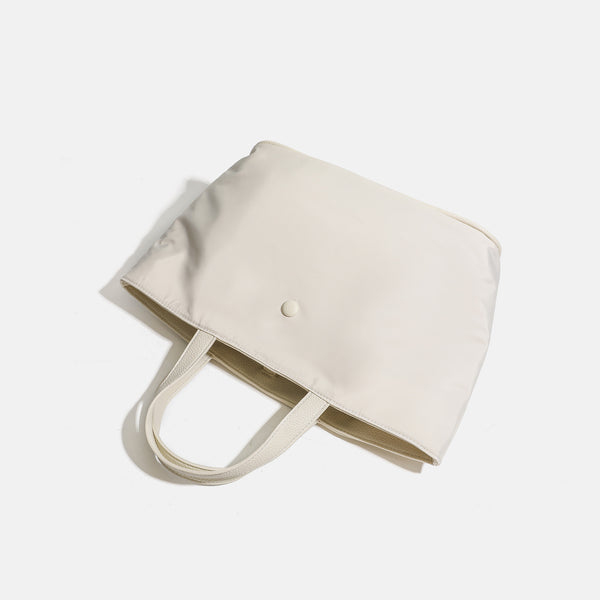 Structured lightweight nylon tote bag with textured double top handles and snap-button front detail, detail view 4