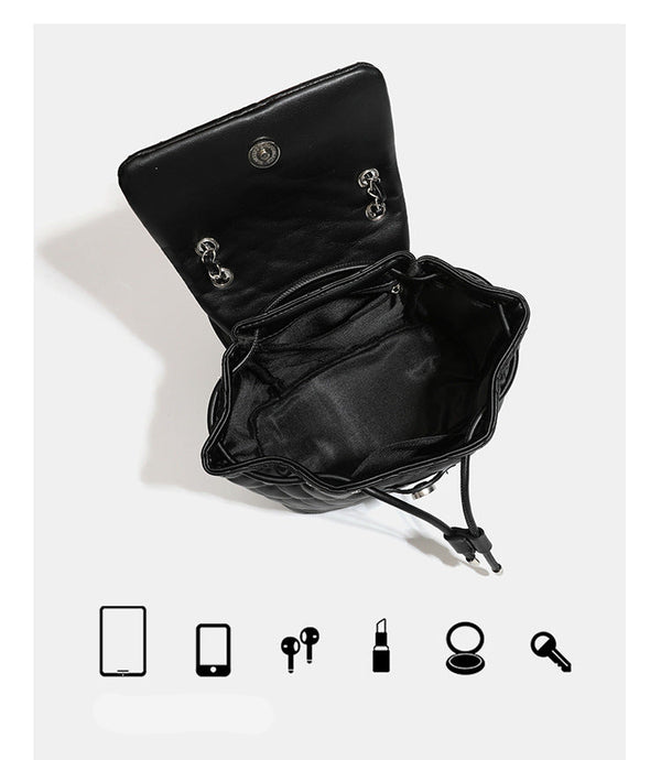 Black diamond-quilted backpack handbag with silver-tone chain flap accent and adjustable shoulder straps, detail view 10