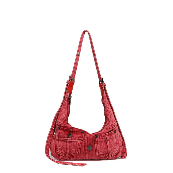 Compact washed red distressed-textile shoulder bag with front flap pockets, dark metal hardware, and long adjustable strap