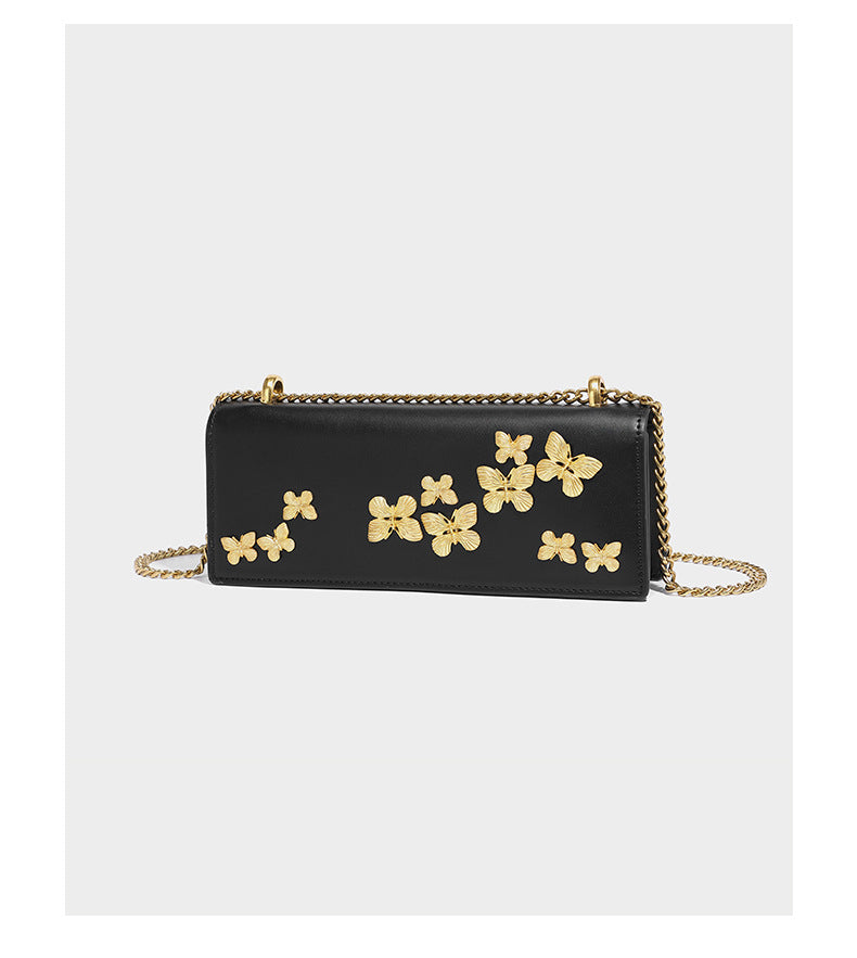 Slim rectangular crossbody bag with gold-tone butterfly metal appliqués and fine antiqued chain strap, detail view 7