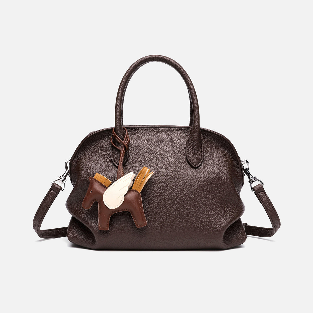 Rounded dome shell handbag in pebbled leather-look finish with twin top handles, zip closure, decorative horse charm, and