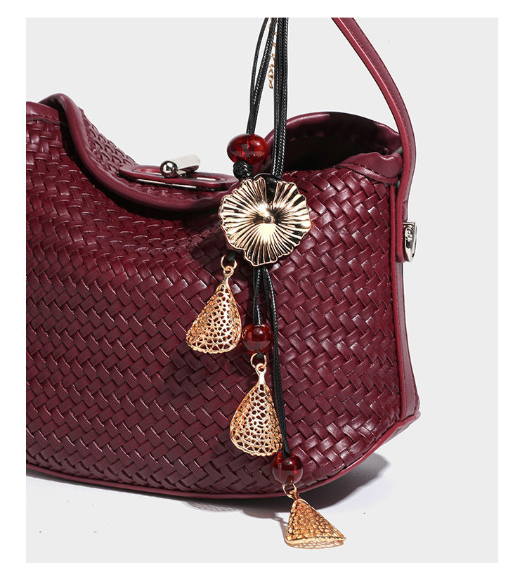 Small woven-look leather-look flap shoulder hobo bag in burgundy with silver-tone hardware and decorative tassel charm