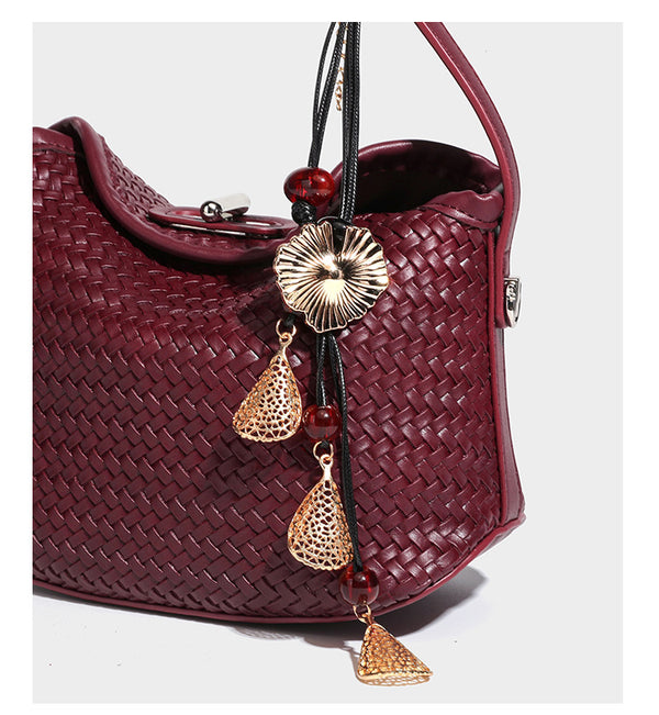 Small woven-look leather-look flap shoulder hobo bag in burgundy with silver-tone hardware and decorative tassel charm