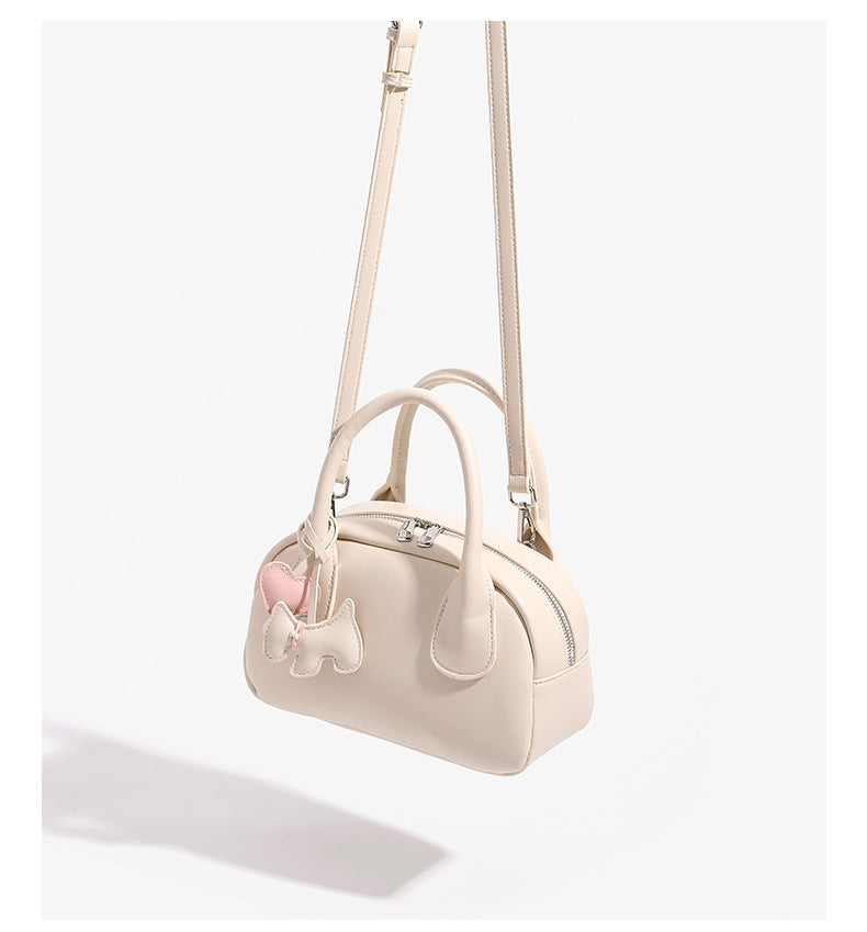 Mini-Handtasche in Kuppelform mit glatter Oberfläche in Lederoptik, zwei Henkeln, Reißverschluss oben, silberfarbenen Metalldetails und herabhängendem