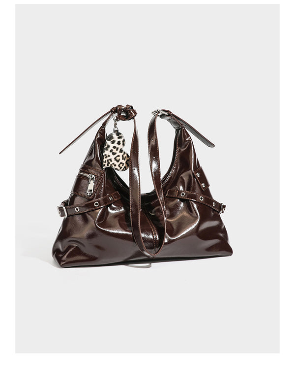 Glänzende, dunkelbraune Hobo-Schultertasche mit silberfarbenen Ösen am Riemen, vorderer Reißverschlusstasche und Herzmotiv im Leopardenprint