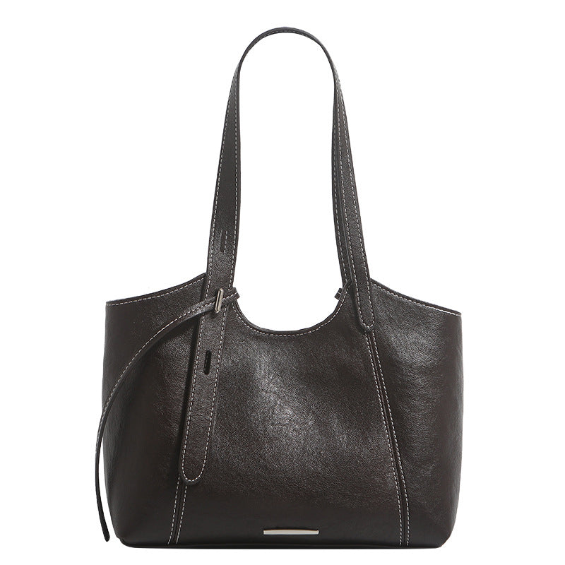 Structured leather-look tote shoulder bag with double crossed straps, contrast topstitching, and metal bar hardware, detail
