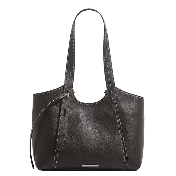 Structured leather-look tote shoulder bag with double crossed straps, contrast topstitching, and metal bar hardware, detail
