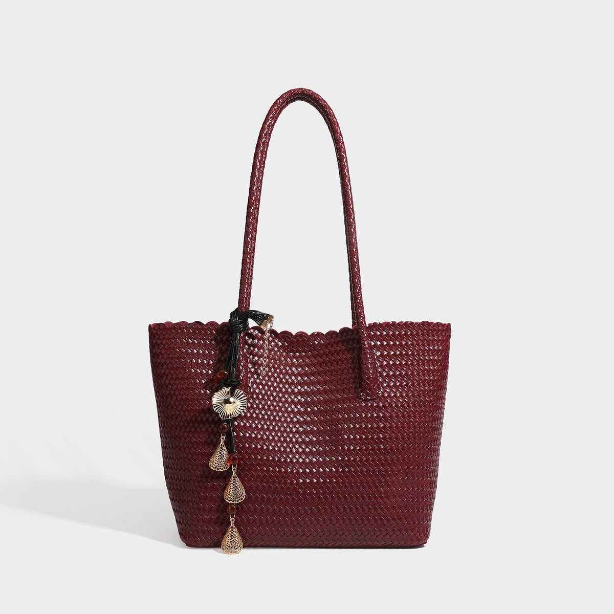 Large open-top woven leather-look tote bag in dark brown with scalloped edge, braided double shoulder straps, and decorative