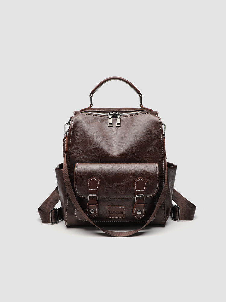 Structured black leather-look convertible backpack handbag with brown contrast trim, buckle front pocket, double-zip top