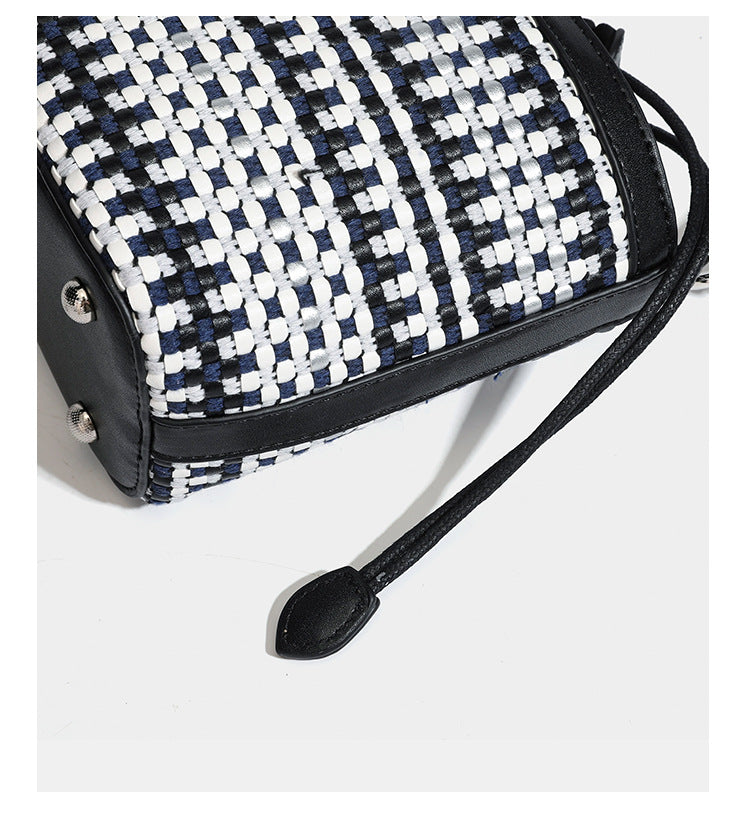Small structured woven checker bucket bag with braided top handle, drawstring closure, and silver-tone hardware in black