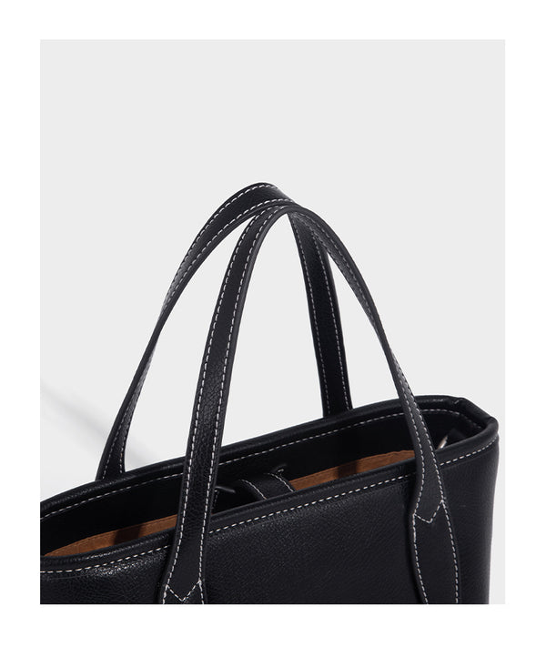 Compact structured bucket tote bag with pebbled textured finish, dual top handles, silver-tone lock hardware, and detachable