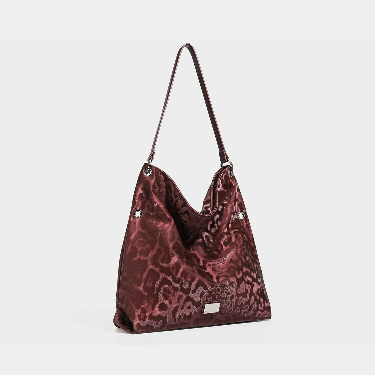 Lässig fallende Hobo-Schultertasche mit Leopardenprint, glänzender satinähnlicher Oberfläche, silberfarbenen Ringbeschlägen und schmalem Schulterriemen