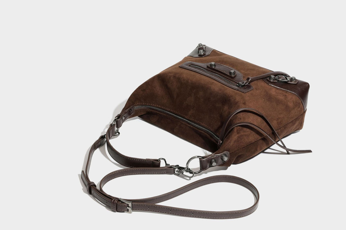 Slouchy suede-finish hobo shoulder bag with dark hardware, exterior zip pocket, tassel ties, and detachable crossbody strap
