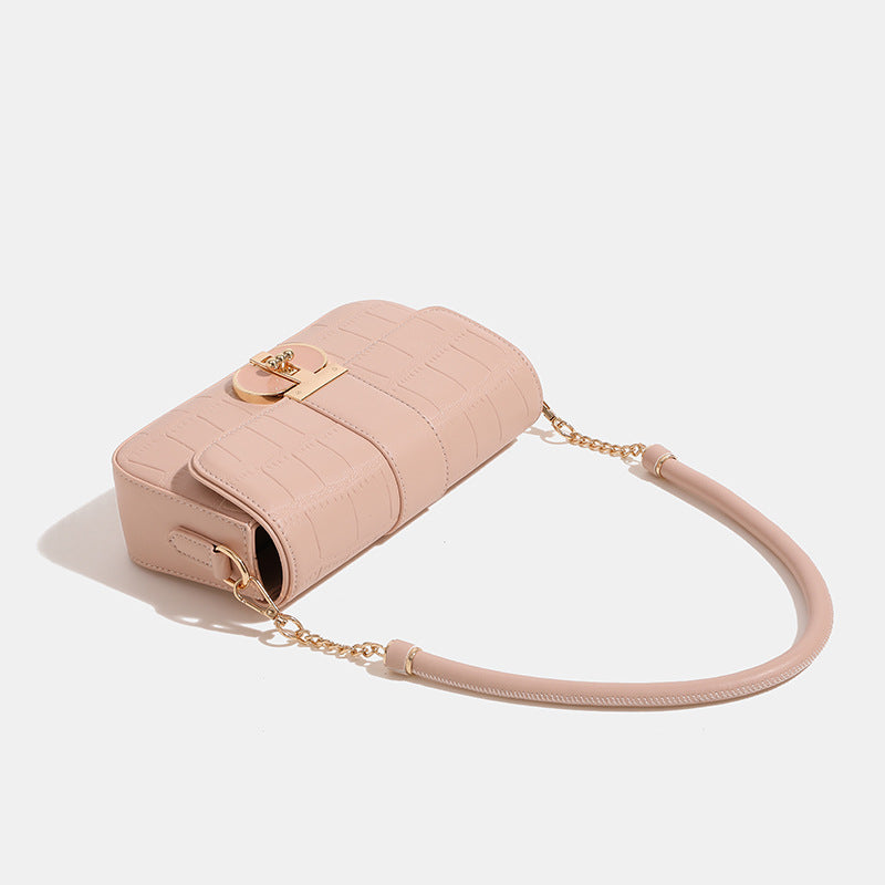 Small crocodile-embossed flap crossbody bag with circular gold turn-lock closure and chain strap, detail view 3